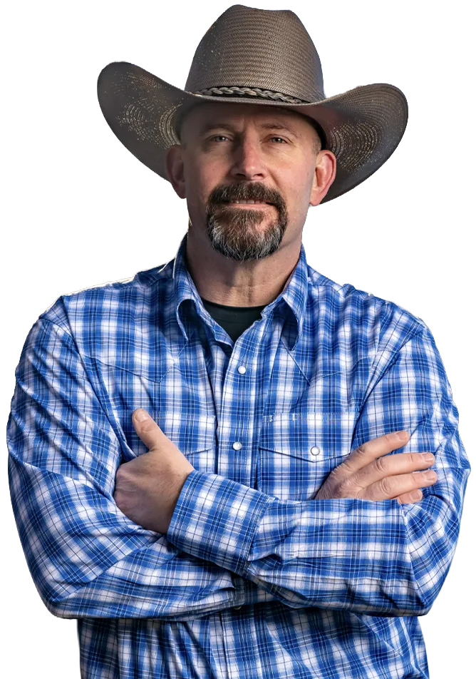 Chris Lee in a cowboy hat and blue plaid shirt with his arms crossed