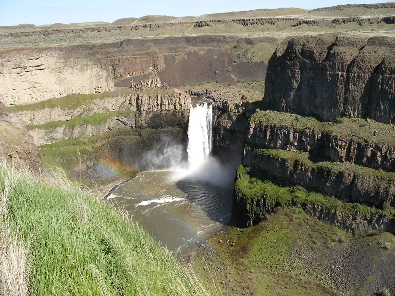 Palouse Falls plunging into a basalt canyon with a rainbow in the mist